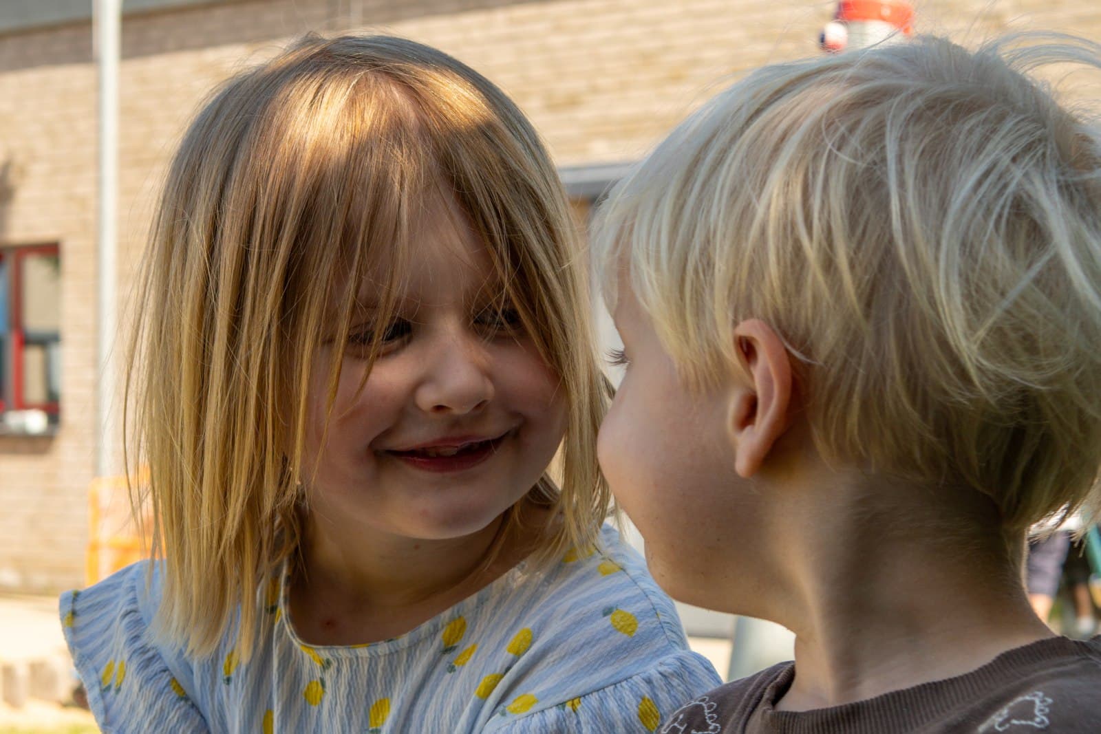 Zwei Kinder im vertrauten Gespräch, echtes Lachen